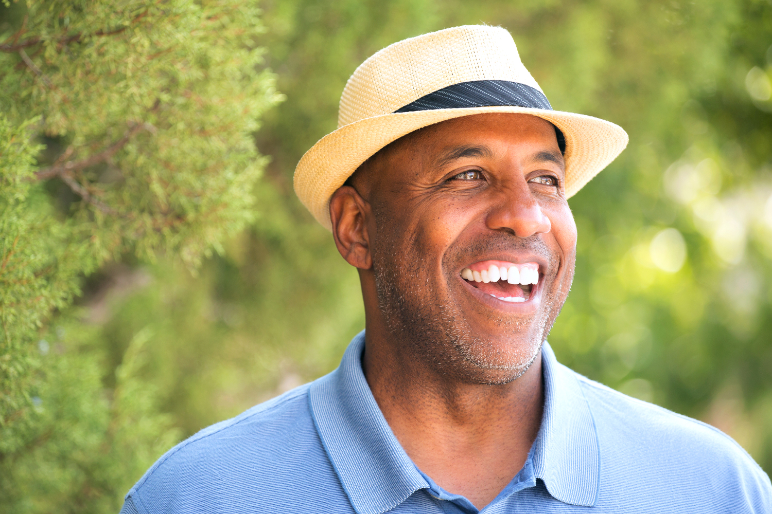 a man wearing a hat and smiling at the camera