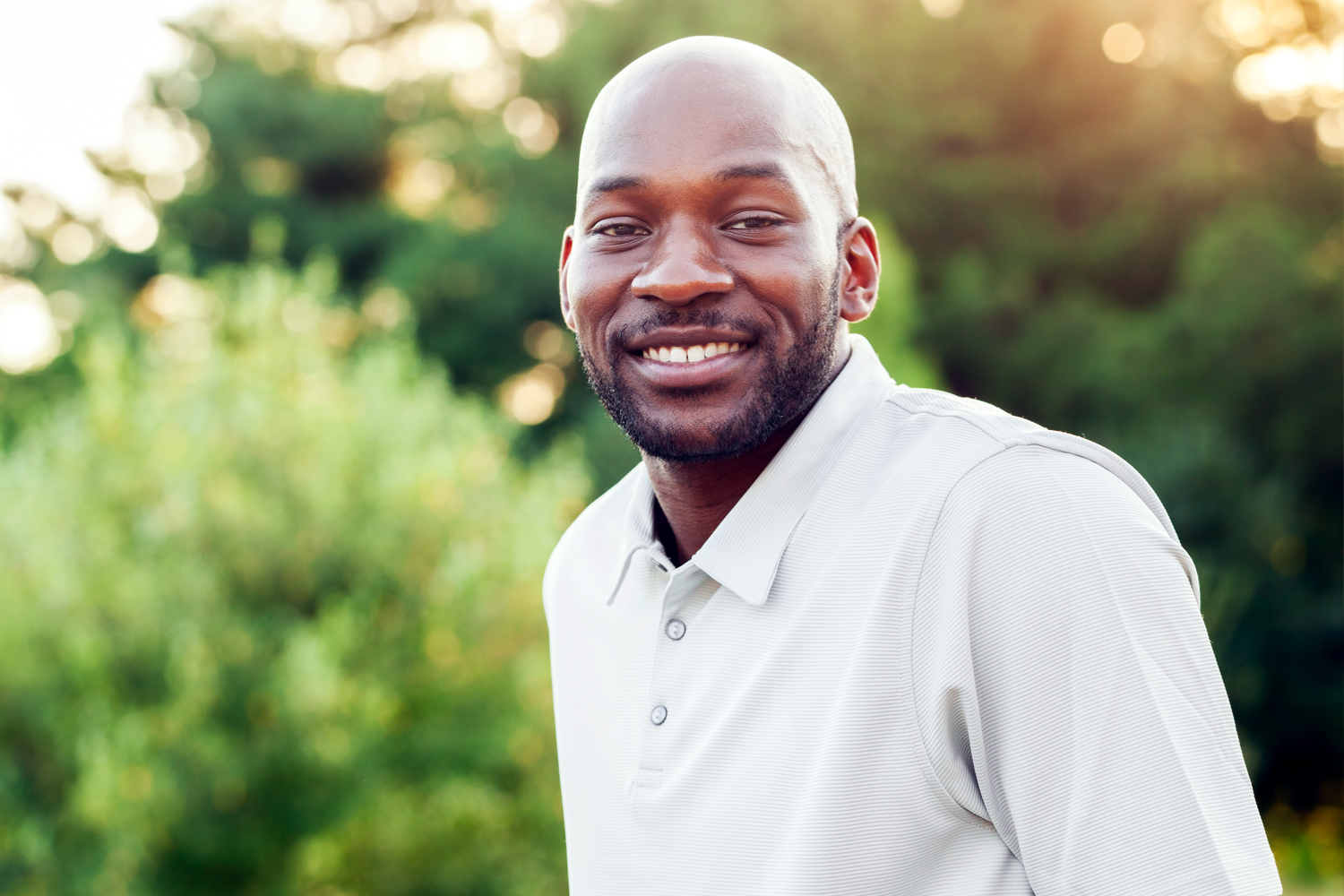 a man wearing glasses and smiling at the camera