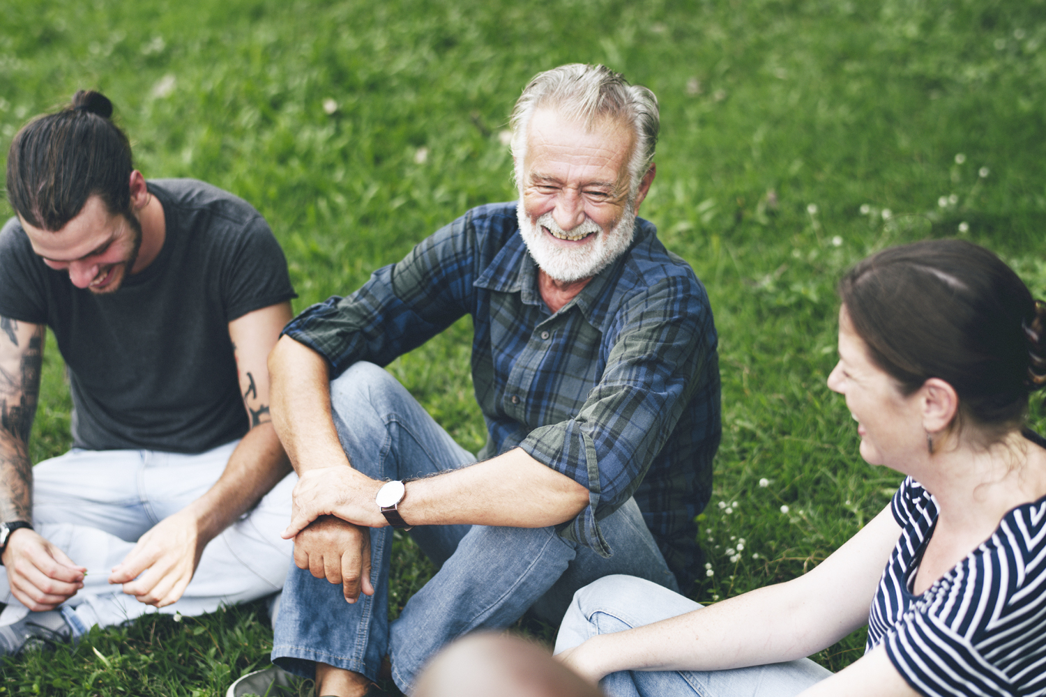 a group of people sitting in the grass
